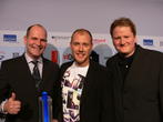 Die Preisträger Benedikt Schüler (Ubisoft) und Anno-Producer Christopher Schmitz nehmen Laudator Oli P. in die Mitte. Die Preisträger Benedikt Schüler (Ubisoft) und Anno-Producer Christopher Schmitz nehmen Laudator Oli P. in die Mitte.
