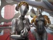 Zwei weibliche Roboterfiguren, von denen eine einen Schlüssel in der Hand hält.