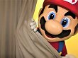 Das Nintendo-Maskottchen Super Mario spitzt hinter einem Vorhang hervor