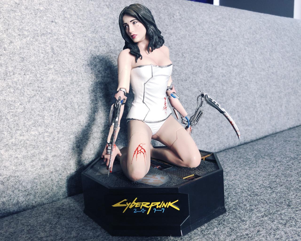 [15/02/2019] Diese Figur eines weiblichen Cyborgs aus Cyberpunk 2077 wurde 2018 auf der E3 und Gamescom an Besucher der Spielepräsentation verschenkt und wurde kurz darauf zu hohen Preisen auf Onlinemarktplätzen gehandelt.