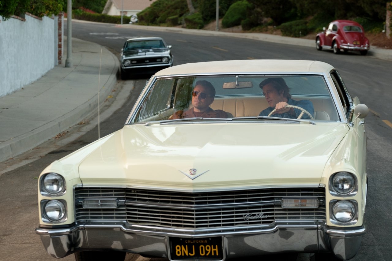 Cliff Booth (Brad Pitt) und Rick Dalton (Leonardo DiCaprio) fahren durch Hollywood.