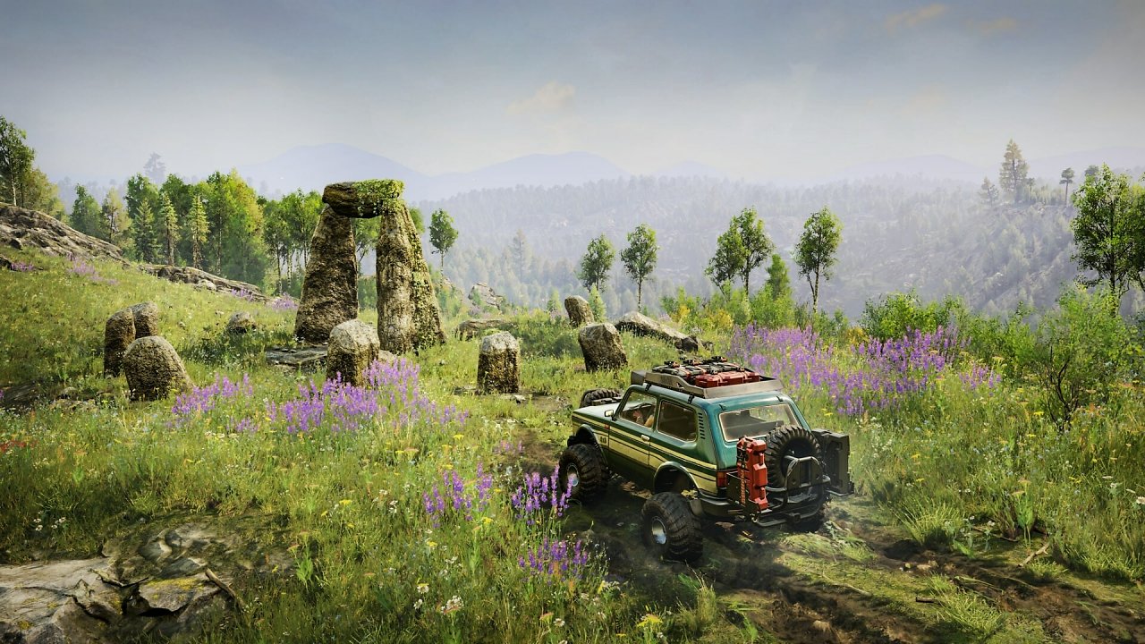 Ein Jeep fährt duch grünes Terrain.