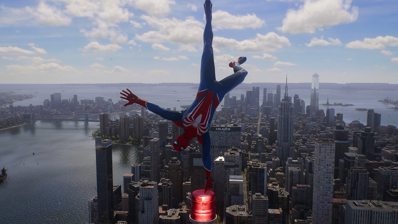 Spider-Man balanciert auf einem Finger auf der Spitze eines Wolkenkratzers mit New Yorks Skyline im Hintergrund.
