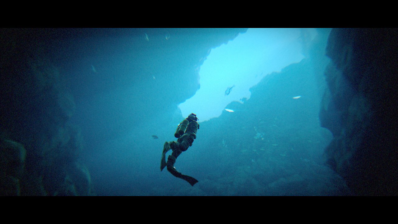 Ein Taucher steigt aus einer Unterwasserhöhle empor.