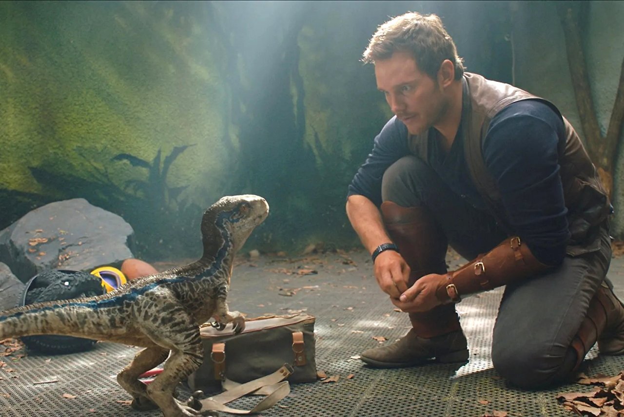 Chris Pratt kniet in Jurassic World vor einem Dino