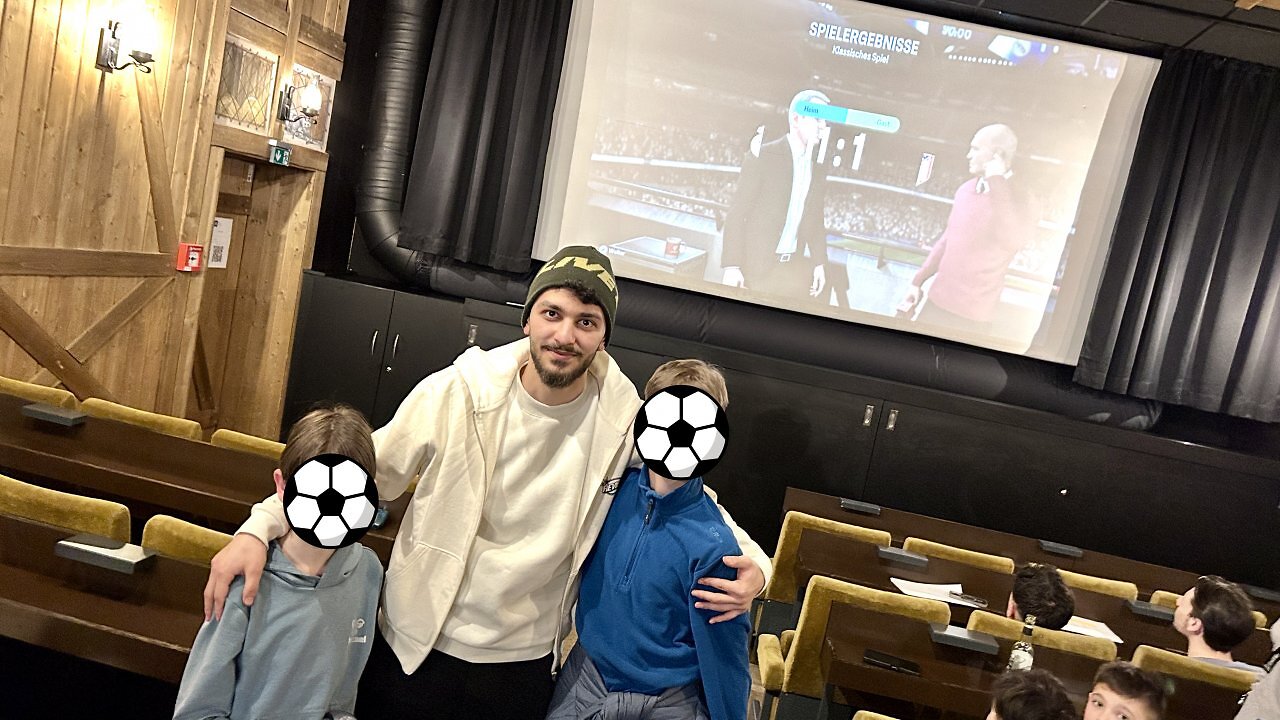 FIFA-Spieler Canik posiert mit Kindern für ein Foto.