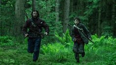 Ein Vater rennt mit seinem Sohn durch den Wald
